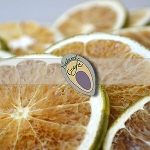 May include: Dried citrus fruit slices, arranged in a pile. The slices are a light brown color and have a translucent appearance. The fruit is arranged in a way that shows the natural texture and detail of the fruit.