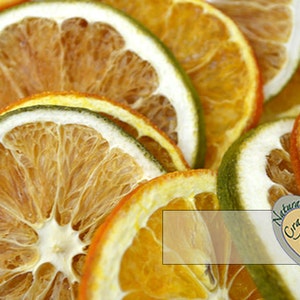 May include: Dried orange and lime slices, arranged in a pile. The slices are a mix of yellow, orange, and green colors. The image has a white background and the text "Natural Crafts" in the bottom right corner.