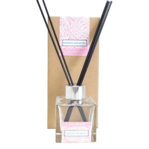 May include: A clear glass bottle with a silver lid and black diffuser sticks. The bottle is labelled "Pink Almond" and "Borders Aromatics".