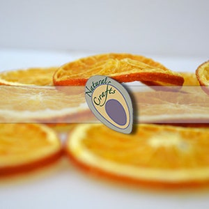 May include: Dried orange slices, a natural craft, arranged on a white surface. The slices are a vibrant orange color and have a slightly translucent appearance.