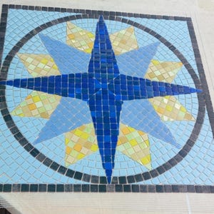 Piscina con mosaico a forma di rosa dei venti su rete, realizzata su ordinazione