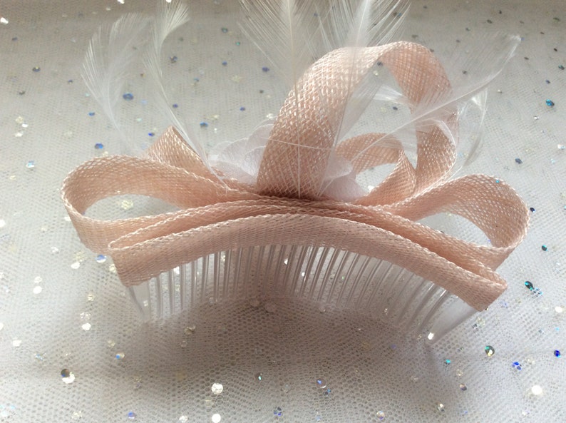 A NUDE PINK and WHITE Fascinator chiffon flower inset with crystals.and pearls Feathers Made with sinamay on a comb