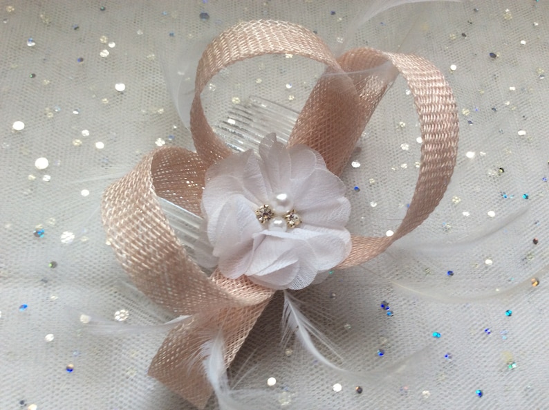 A NUDE PINK and WHITE Fascinator chiffon flower inset with crystals.and pearls Feathers Made with sinamay on a comb