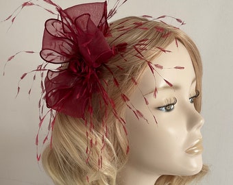 A BURGUNDY ORGANZA FASCINATOR, shimmers gold, with ostrich feathers, flower, on a clip