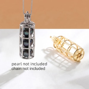 May include: A silver pendant necklace with a cylindrical cage design, holding three dark pearls. A separate gold-coloured cage is also shown. The text "pearl not included chain not included" is visible.