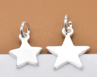 May include: Two silver star-shaped charms with jump rings. The charms are different sizes.