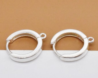 May include: Two silver hoop earrings with a jump ring attached to each hoop.