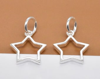 May include: Two silver star-shaped charms with a loop at the top. The stars are hollow and have a smooth, polished finish.