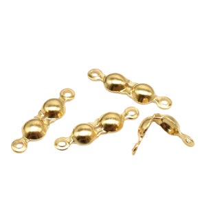 Könnte beinhalten: Vier goldfarbene Metallperlenkappen für die Schmuckherstellung. Jede Kappe hat drei Perlen und zwei Schlaufen zum Anbringen an einer Kette oder Schnur.