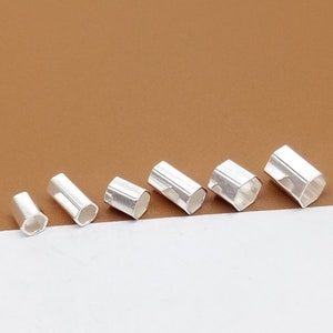 May include: Six silver hexagonal tube end caps of varying sizes. The caps are hollow and have a smooth, shiny finish.