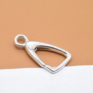 May include: Silver-toned metal clasp with a rounded opening and a triangular shape.