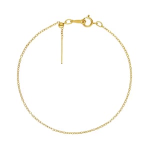 Puede incluir: Un brazalete de cadena de oro con una pequeña bola al final de la cadena y un cierre de langosta.
