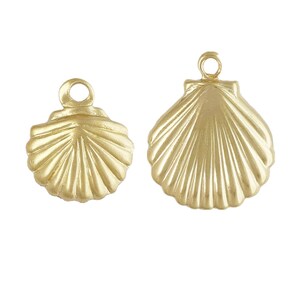 May include: Two gold-coloured metal seashell charms with a loop for hanging. The larger charm is about 5 cm wide and the smaller charm is about 2.5 cm wide.