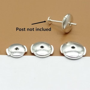 May include: Three silver earring backs, two are flat and one is a post back. The post back is missing the post.  "Post not included" is written on the image.
