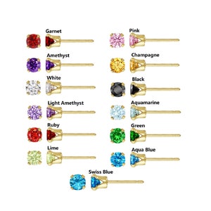 May include: A set of 12 gold stud earrings with different colored gemstones. The colors include garnet, pink, amethyst, white, champagne, black, light amethyst, aquamarine, ruby, lime, green, aqua blue, and swiss blue.