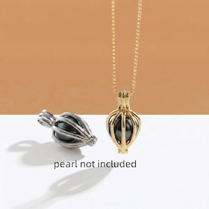 Puede incluir: Un colgante de jaula de metal dorado en una cadena a juego y un colgante de jaula de metal plateado por separado. Ambos colgantes presentan un diseño de marco abierto vertical. El texto "pearl not included" está impreso debajo.