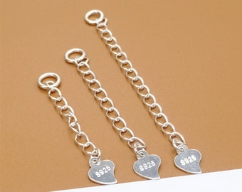 May include: Three silver chain extenders with heart-shaped charms. Each charm is stamped with "S925", indicating sterling silver.