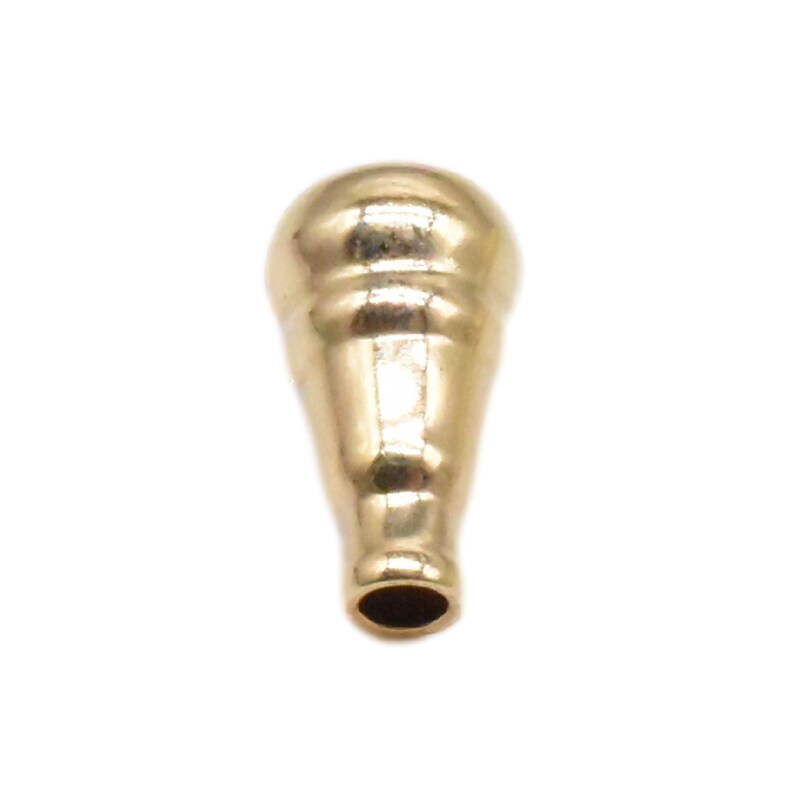 May include: A gold-colored metal bottle stopper with a rounded top and a tapered bottom.