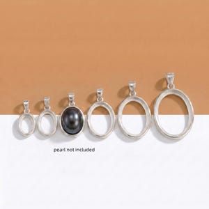 May include: A selection of silver oval pendant settings in different sizes, one holding a dark grey pearl. The text "pearl not included" is visible. These settings are for jewellery making.