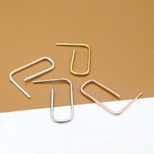 May include: Four earring hoops in different colors: gold, silver, and rose gold. The hoops are all the same size and shape, and they are arranged in a semi-circle.