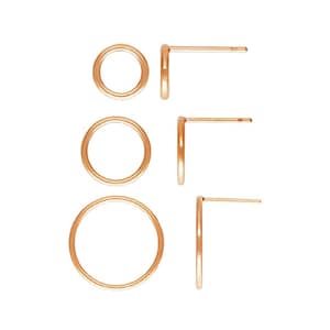 Peut inclure: Ensemble de trois boucles d'oreilles créoles dorées de tailles différentes. Les boucles d'oreilles sont en métal et ont un design simple et minimaliste.