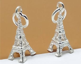 May include: Two silver Eiffel Tower charms with a loop at the top for attaching to a necklace or bracelet.