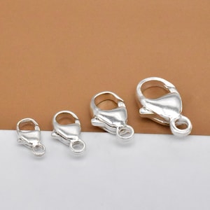 May include: Four silver lobster claw clasps of different sizes. The clasps are a popular jewellery finding for necklaces, bracelets, and other jewellery projects.