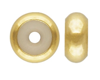 May include: Gold-toned bead with a white center and a hole in the center. The bead is round and has a smooth surface.