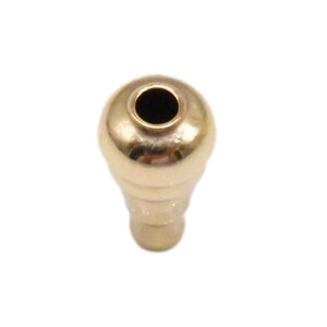 May include: A gold-toned metal bead with a round top and a smaller, cylindrical bottom. The bead has a hole in the center of the top.