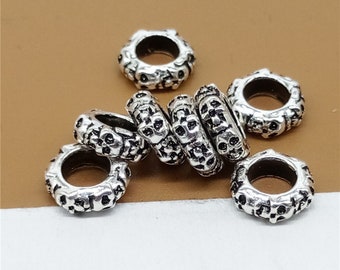 May include: Silver skull bead charms for jewelry making. The beads are round and have a detailed skull design.