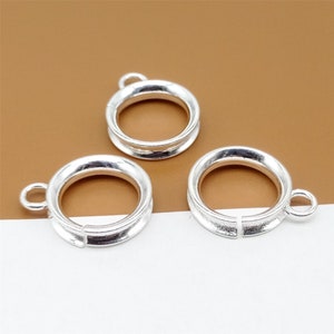 May include: Three silver-toned metal rings with a loop on one side. The rings are open on one side and can be used for jewelry making.