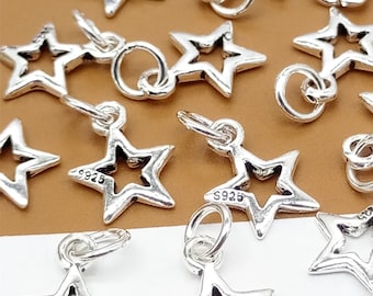 May include: A group of silver star-shaped charms with a loop for attaching to a bracelet or necklace. The charms are marked with "S925", indicating they are made of sterling silver.