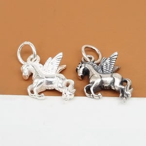 Peut inclure: Deux breloques en argent en forme de cheval ailé, l'une avec une finition polie et l'autre avec une finition oxydée.