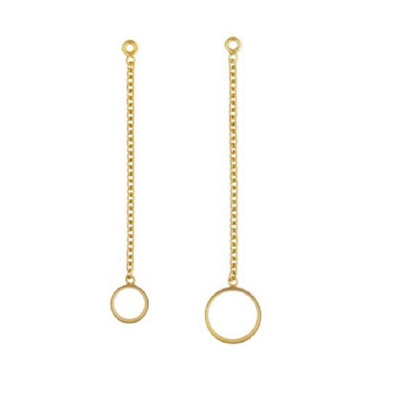 May include: Two gold chain earrings with a circle pendant at the end of each chain.