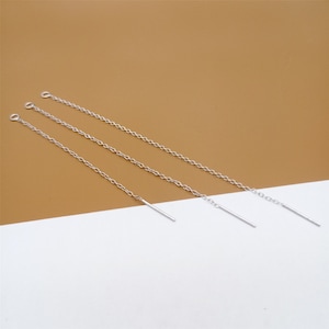 Può includere: Tre orecchini a catena d'argento con un pendente a barra dritta alla fine di ogni catena.