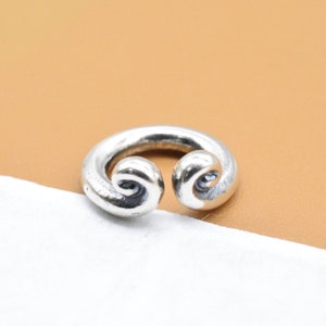 Peut inclure: Bague en argent avec un design unique en double spirale.