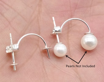 May include: Two silver earring posts with a curved back, designed to hold a pearl. The text "Pearls Not Included" is visible below the earrings.