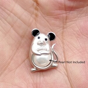 Pode incluir: Encanto de prata em forma de rato segurando uma pérola. A pérola não está incluída.  Pearl Not Included.
