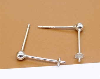 May include: Two silver earring posts with a round ball on one end and a flat disc on the other end.