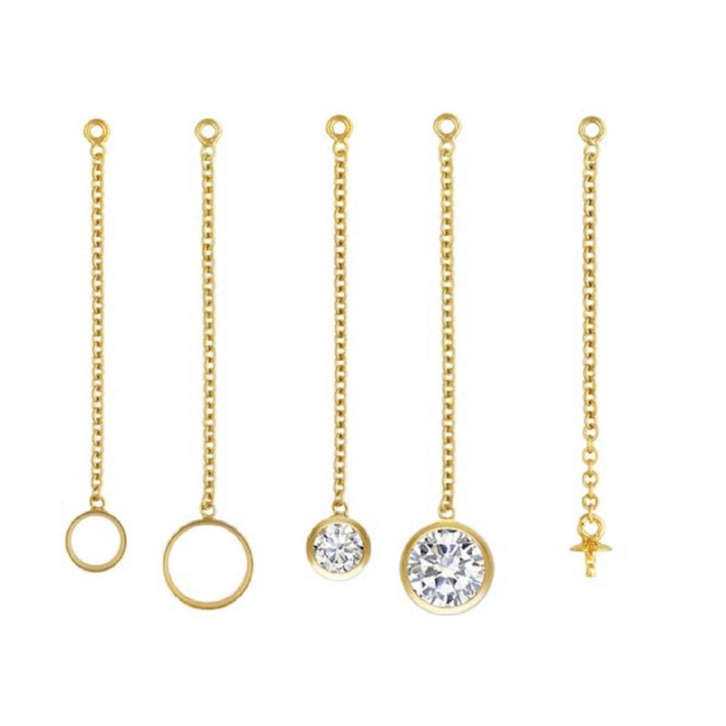 May include: Five gold chain earring extenders with different end pieces. The extenders feature a round loop, a round circle, a small round clear stone, a larger round clear stone, and a small gold screw-on charm.