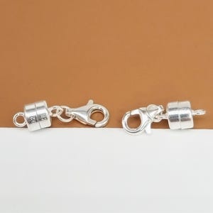 Pode incluir: Dois fechos magn&eacute;ticos de prata para colares ou pulseiras. Cada fecho tem um fecho de lagosta de prata e uma pe&ccedil;a magn&eacute;tica redonda marcada com "925".