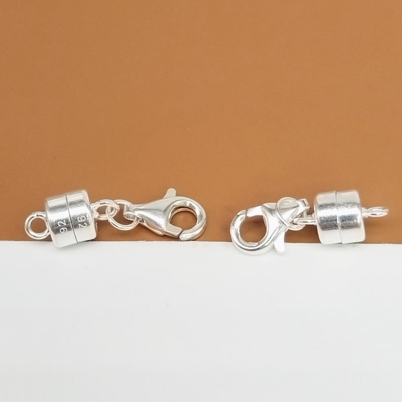 Pode incluir: Dois fechos magn&eacute;ticos de prata para colares ou pulseiras. Cada fecho tem um fecho de lagosta de prata e uma pe&ccedil;a magn&eacute;tica redonda marcada com "925".