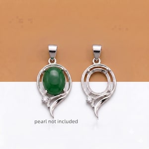 May include: Two silver-toned pendant settings with a teardrop-shaped frame and a small clear stone accent. One pendant features an oval green cabochon stone, while the other is empty. The text "pearl not included" is visible below the pendants.