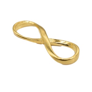 Puede incluir: Un amuleto de oro en forma de símbolo de infinito, una opción popular para la elaboración de joyas.