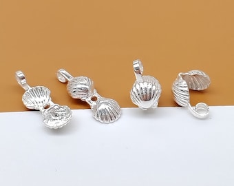May include: Three silver shell-shaped clasps for jewelry making. Each clasp has a loop on one end and a shell design on the other.