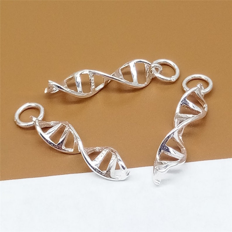 K&ouml;nnte beinhalten: Drei silberfarbene DNA-Doppelhelix-Anh&auml;nger. Jeder Anh&auml;nger hat ein detailliertes, gedrehtes Doppelhelix-Design. Die Anh&auml;nger haben einen Sprungring zum Anbringen an einer Halskette oder einem Armband.