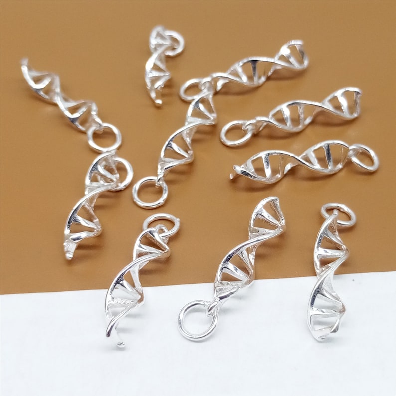 K&ouml;nnte beinhalten: Ein Set mit zehn silberfarbenen DNA-Doppelhelix-Anh&auml;ngern. Die Anh&auml;nger sind alle gleich gro&szlig; und haben die gleiche Form und eignen sich perfekt, um Ihren Schmuck mit einem Hauch von Wissenschaft zu versehen.