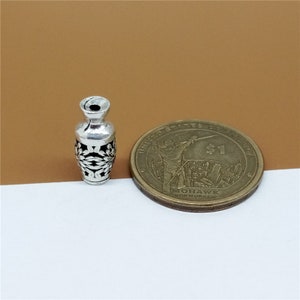 K&ouml;nnte beinhalten: Silberner Vasen-Anh&auml;nger mit einem filigranen Design. Die Vase ist etwa so gro&szlig; wie eine 1-Euro-M&uuml;nze.