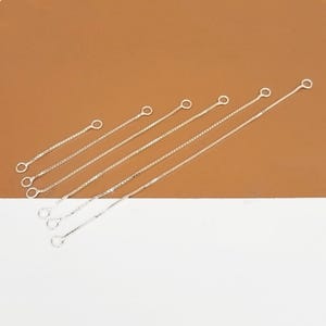 Puede incluir: Un conjunto de siete extensores de cadena plateados con anillas de unión en cada extremo. Los extensores están ordenados por longitud, siendo el más corto el de arriba y el más largo el de abajo.