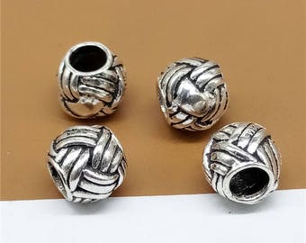 May include: Four silver-toned metal beads with a woven design. The beads are round and have a hole in the centre.
